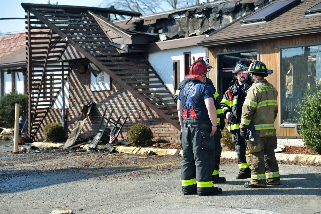 Firefighters at the site of the Wind Tiki in Webster March 18.