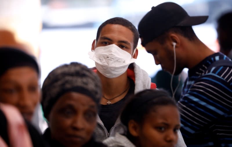 A commuter wears a mask to combat the spread of coronavirus disease (COVID-19) at a bus depot in Cape Town