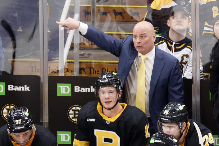 Boston Bruins head coach Jim Montgomery directs his team from the bench during the second period of an NHL hockey game against the Detroit Red Wings, Saturday, March 11, 2023, in Boston. (AP Photo/Mary Schwalm)