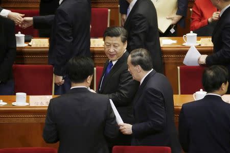 FILE PHOTO: Wang Qishan (centre R), China's Politburo Standing Committee member and head of China's anti-corruption watchdog, talks to President Xi Jinping (centre L) as they leave after the opening session of the Chinese People's Political Consultative Conference (CPPCC) at the Great Hall of the People in Beijing, China, March 3, 2016. REUTERS/Jason Lee