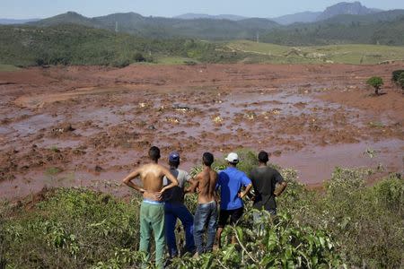 Residents observe the Bento Rodrigues district covered with mud after a dam owned by Vale SA and BHP Billiton Ltd burst in Mariana, Brazil, November 6, 2015. REUTERS/Ricardo Moraes