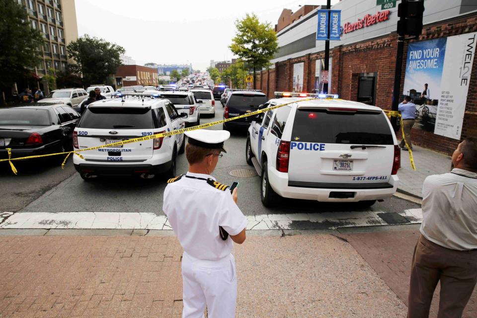 Bystanders look for more information as police respond to reports of a shooting and subsequent lockdown at the U.S. Navy Yard in Washington