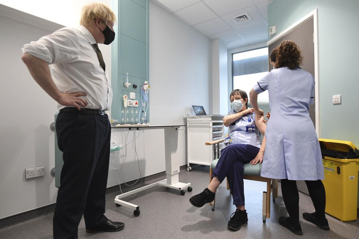 Britain's Prime Minister Boris Johnson watches as junior sister Susan Cole is injected with the Oxford-AstraZeneca COVID-19 vaccine during a visit to view the vaccination program at the Chase Farm Hospital in north London on Monday, Jan. 4, 2021, part of the Royal Free London NHS Foundation Trust.