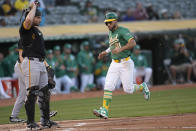 Oakland Athletics' Abraham Toro, right, runs home to score next to Pittsburgh Pirates catcher Joey Bart during the second inning of a baseball game in Oakland, Calif., Tuesday, April 30, 2024. (AP Photo/Jeff Chiu)
