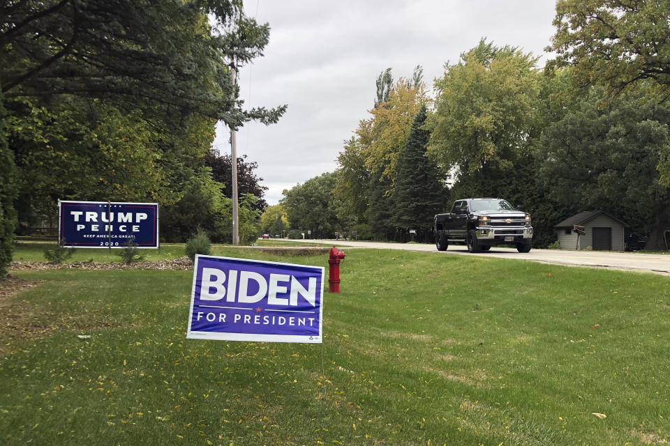 Signs for Democratic presidential candidate former Vice President Joe Biden and President Donald Trump mark neighboring property in a middle-class neighborhood of Oshkosh, the hub of swing-voting Winnebago County Wis. Trump’s standing with white, working class voters has proven resilient through federal investigations, impeachment and countless episodes of chaotic governing. But if those issues were too distant — centered on complicated foreign entanglements — reports about his tax avoidance might have had the potential to hit closer to home during a time of economic upheaval. (AP Photo/Thomas Beaumont)