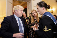 Britain's Prime Minister Boris Johnson and his girlfriend Carrie Symonds, center, speak to guests at a military reception held at 10 Downing Street, London, Wednesday, Sept. 18, 2019. Johnson was accused by European Union officials Wednesday of failing to negotiate seriously and branded the "father of lies" by a lawyer in the U.K. Supreme Court, as his plan to leave the EU in just over six weeks faced hurdles on both sides of the Channel. (Jon Nguyen/Pool Photo via AP)