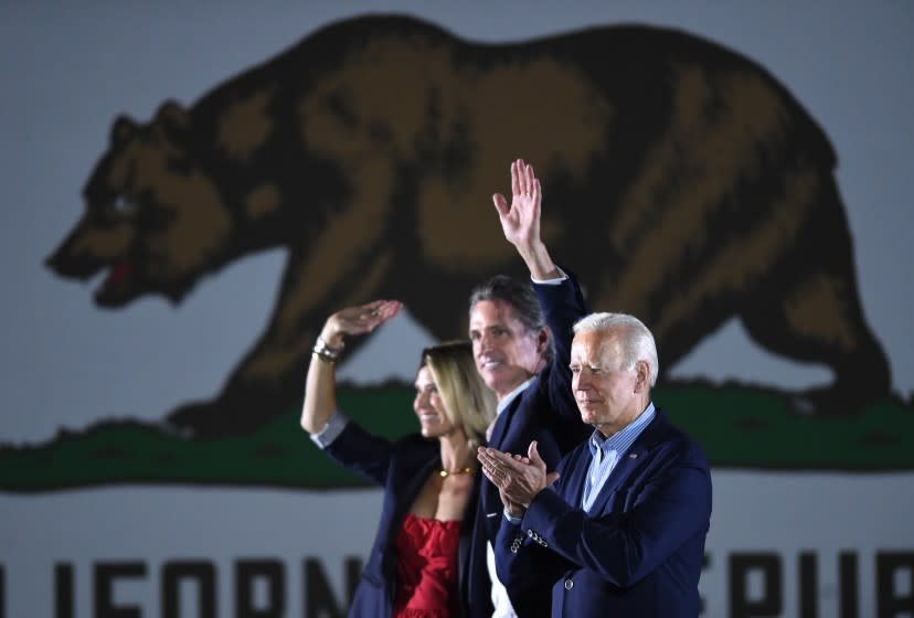 Long Beach, CA - September 13: U.S. US President Joe Biden (L) waves onstage with California Governor Gavin Newsom and his wife Jennifer Siebel Newsom during a campaign event at Long Beach City Collage, on Monday, Sept. 13, 2021 in Long Beach, CA. (Wally Skalij / Los Angeles Times)