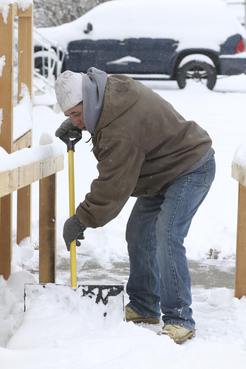 Martin Rabago shovel snow from a walkway in Scottsbluff, Neb., Tuesday, Nov. 26, 2019. "It's heavy snow," he said. But "it's Nebraska and it's that time of year." The snow started falling Monday late afternoon and continued through Tuesday morning. (Brad Staman/The Star-Herald via AP)