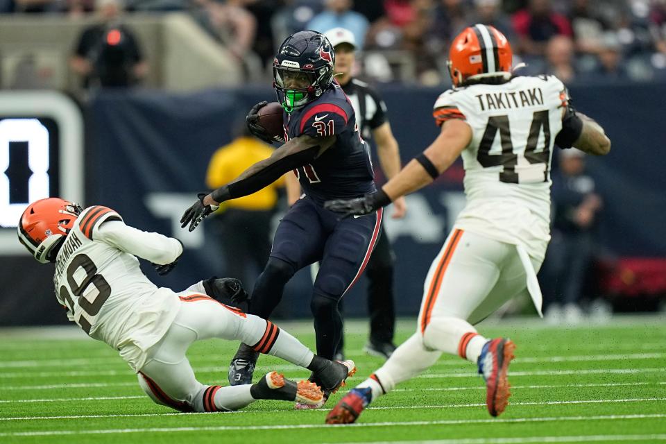 Houston Texans running back Dameon Pierce (31) evades a tackle by Cleveland Browns linebacker Jeremiah Owusu-Koramoah (28) during the first half of an NFL football game between the Cleveland Browns and Houston Texans in Houston, Sunday, Dec. 4, 2022,. (AP Photo/Eric Gay)