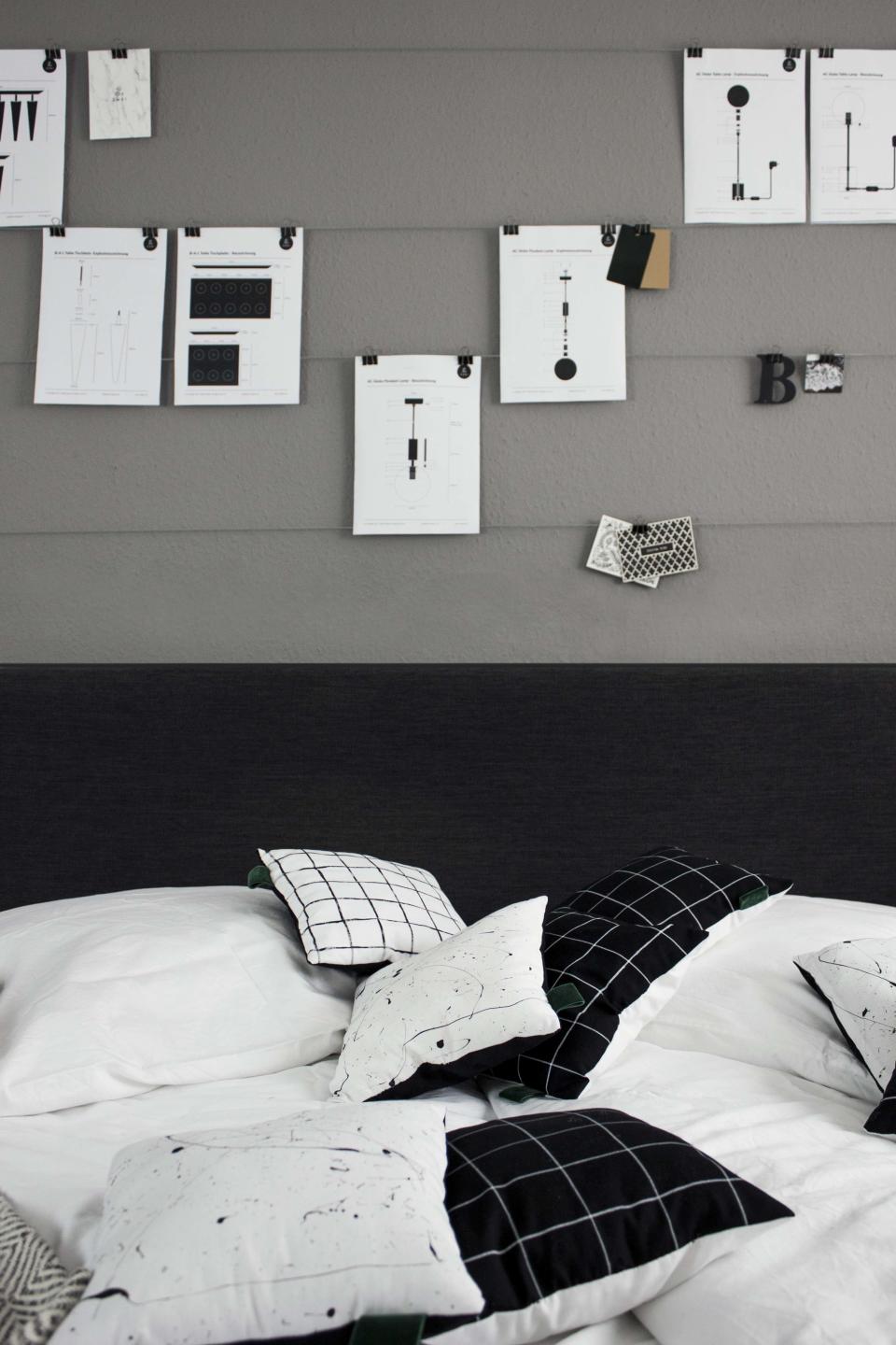 Above the headboard in their bedroom, simple horizontal wires are strung with art, notes, postcards, and more—eliminating messy stacks and adding decoration that can be switched at will.