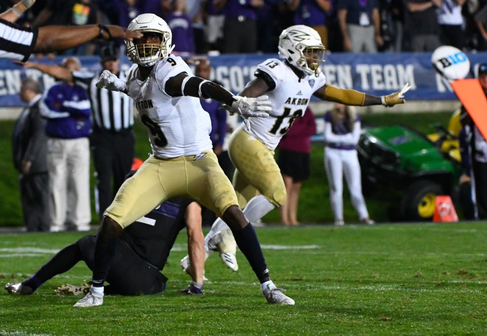 Akron defensive end Jamal Davis II (9) and defensive back Denzel Butler (13) celebrate at the end of their upset of Northwestern in Evanston, Ill., Saturday, Sept. 15, 2018. Akron won 39-34.