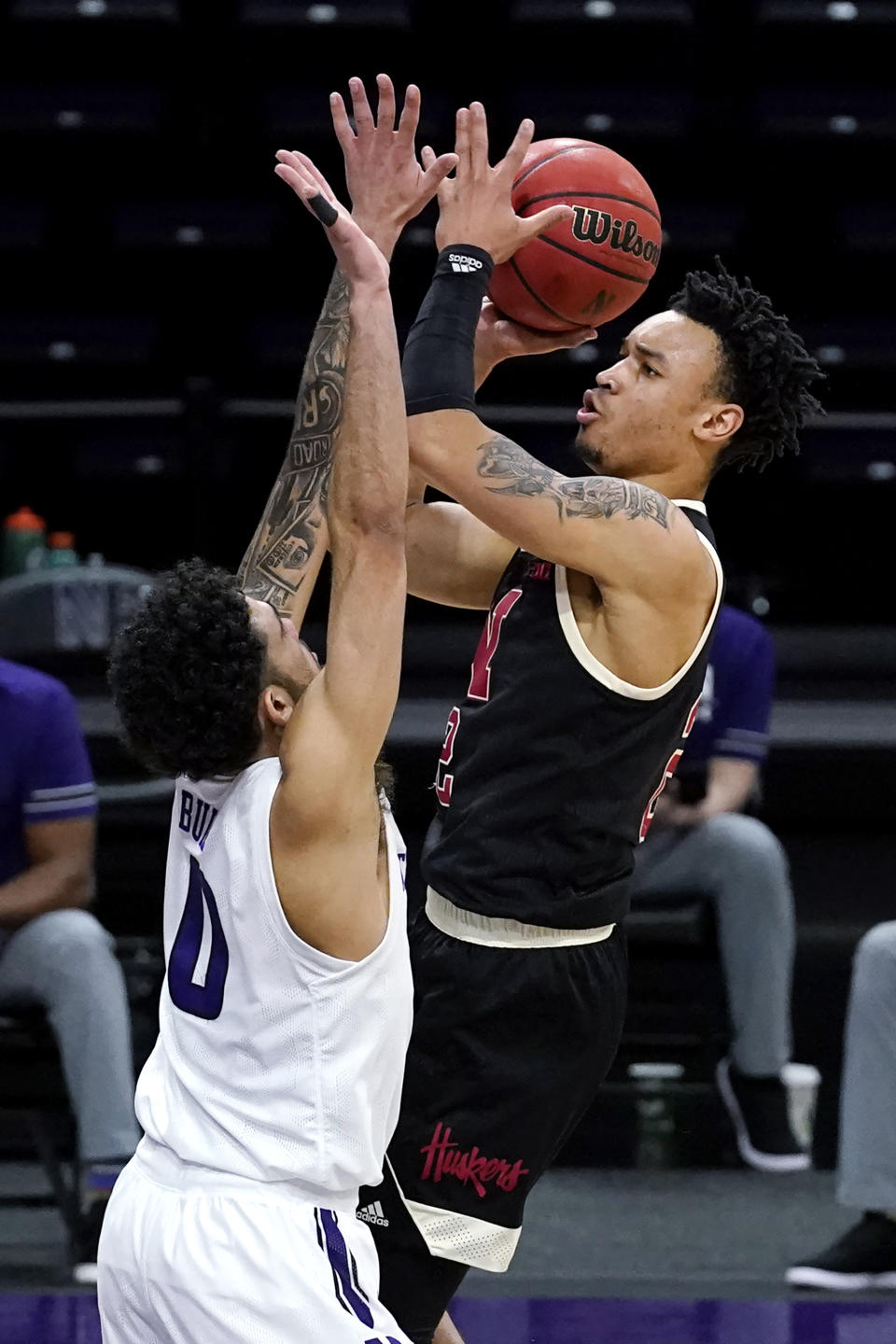 Nebraska guard Trey McGowens, right, shoots against Northwestern guard Boo Buie during the first half of an NCAA college basketball game in Evanston, Ill., Sunday, March 7, 2021. (AP Photo/Nam Y. Huh)