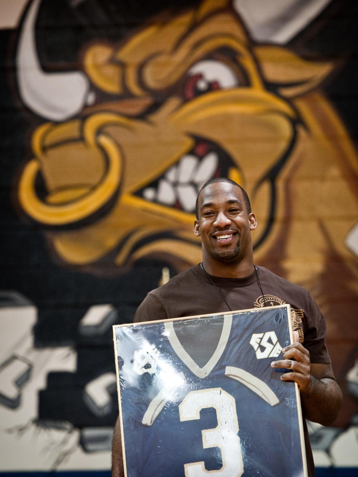 Seattle Seahawk and E.E. Smith alumni Aaron Curry holds up his high school football jersey during his jersey retirement ceremony at E.E. Smith High School in 2010.