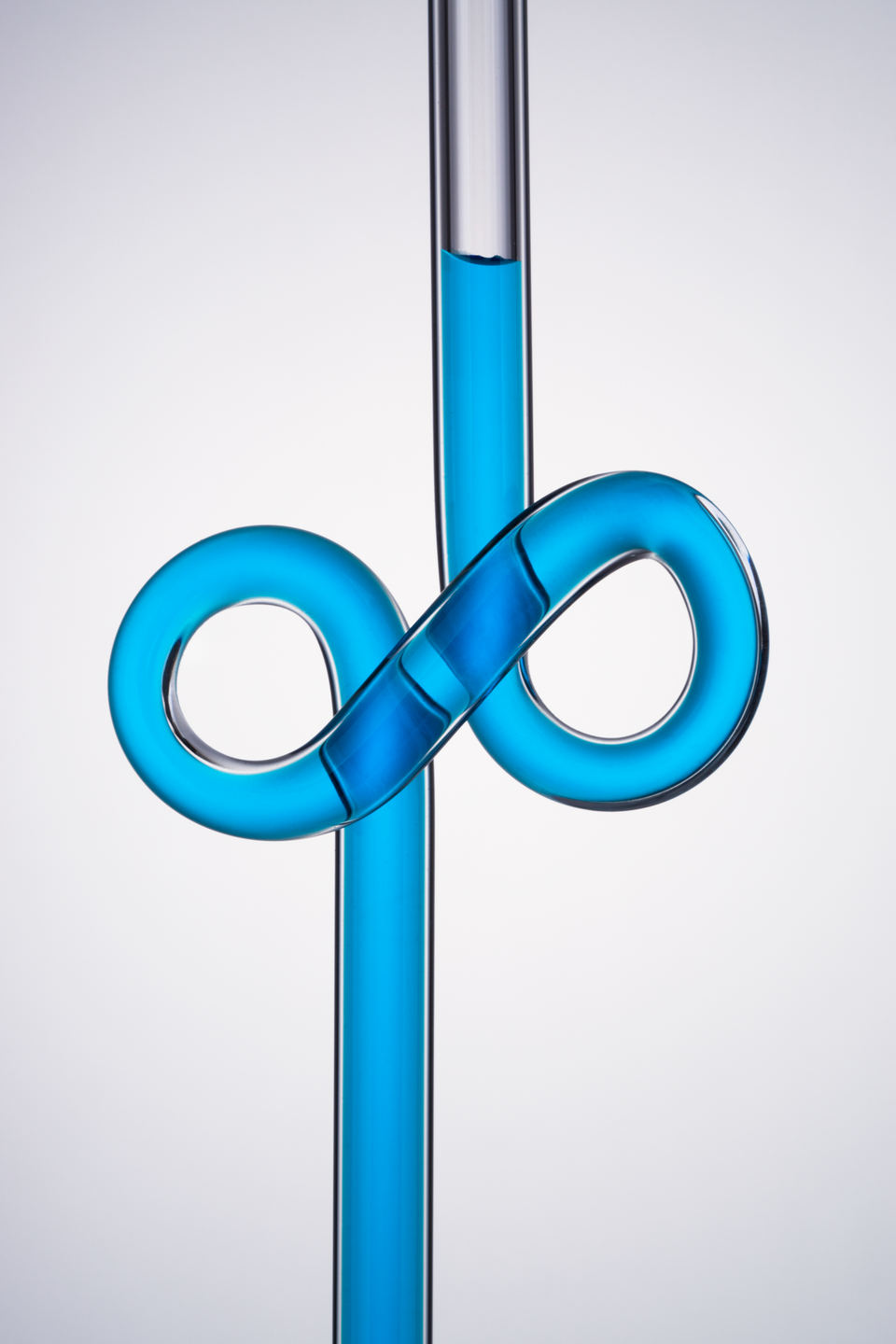 infinity symbol shaped glass tube with blue liquid on white background