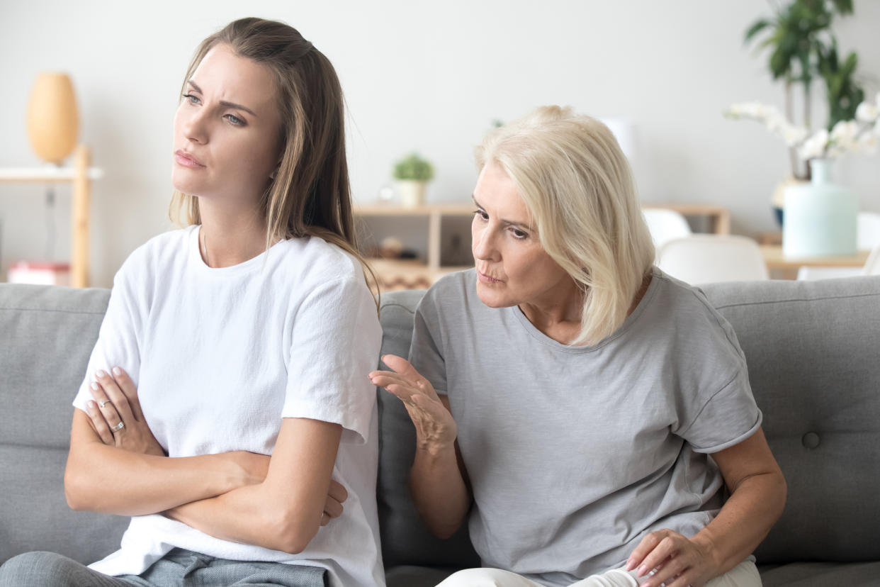 Controlling elderly mother scolding adult daughter having serious conversation with her.