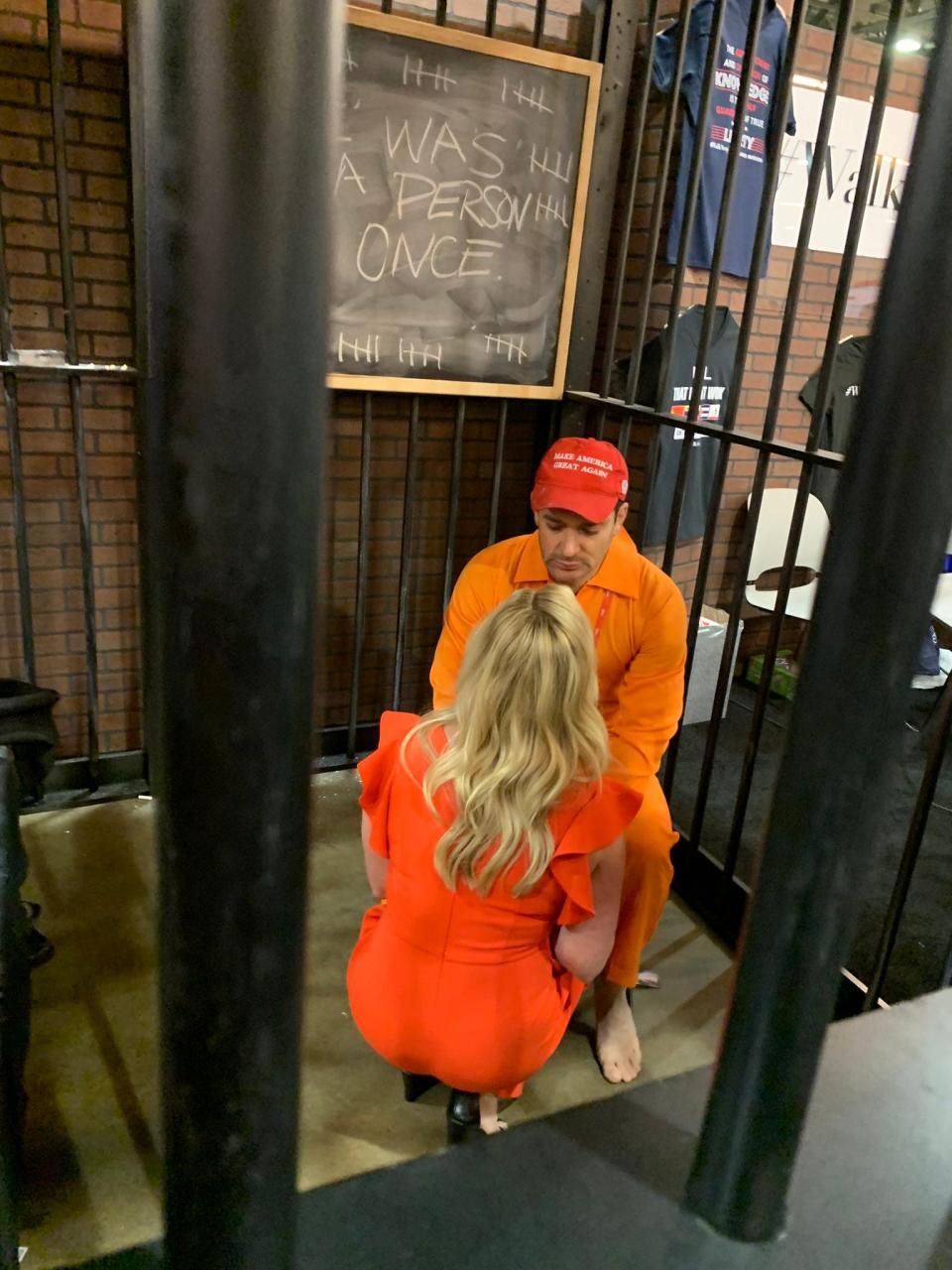 Rep. Marjorie Taylor Greene, R-Ga., pretends to console Brandon Straka, who is pretending to cry in a cell at the Conservative Political Action Conference in Dallas on Aug. 5, 2022.