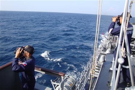 Philippine Navy crew members onboard the Barko ng Republika ng Pilipinas Apolinario Mabini (Patrol Ship 36) scour the West Philippine Sea, as they search for the missing Malaysia Airline MH370 plane, in this March 10, 2014 picture supplied by the Philippine Navy. REUTERS/PS-36 Philippine Navy/Handout via Reuters