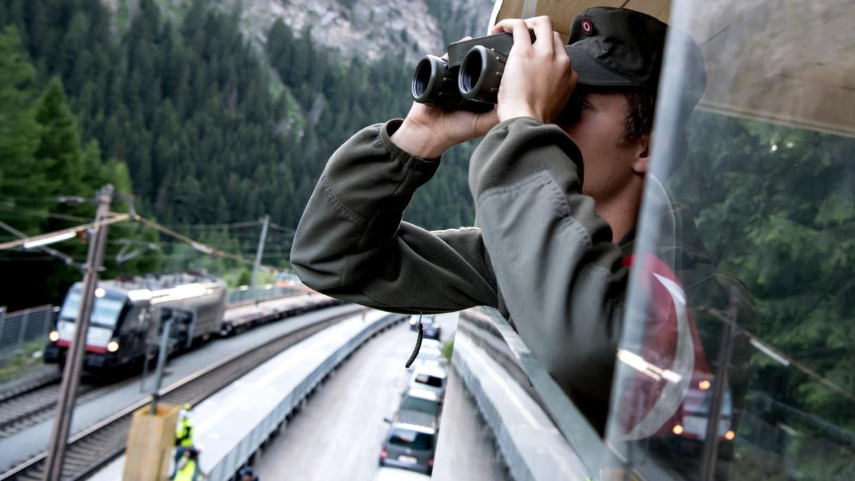 Ein Soldat des österreichischen Bundesheers beobachtet am Brenner eine Kontrollstelle für Güterzüge. Foto: Sven Hoppe