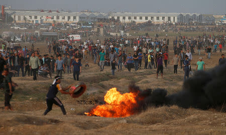 Palestinian demonstrators gather at the Israel-Gaza border fence during a protest calling for lifting the Israeli blockade on Gaza and demanding the right to return to their homeland, in Gaza October 19, 2018. REUTERS/Mohammed Salem