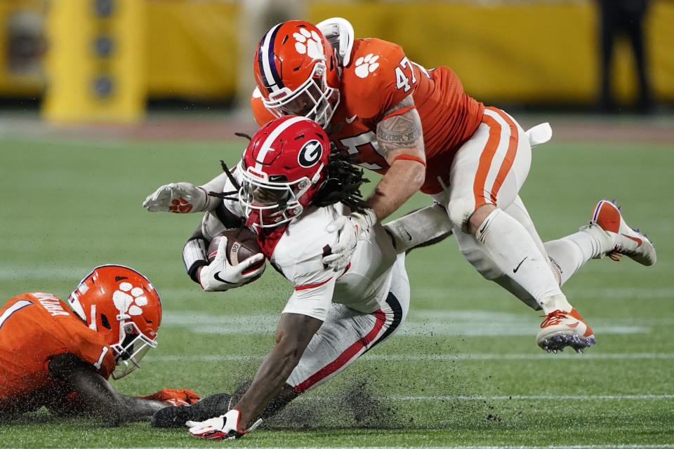 Georgia running back James Cook is tackled by Clemson linebacker James Skalski (47) and safety Andrew Mukuba during an NCAA college football game Saturday, Sept. 4, 2021, in Charlotte, N.C. (AP Photo/Chris Carlson)