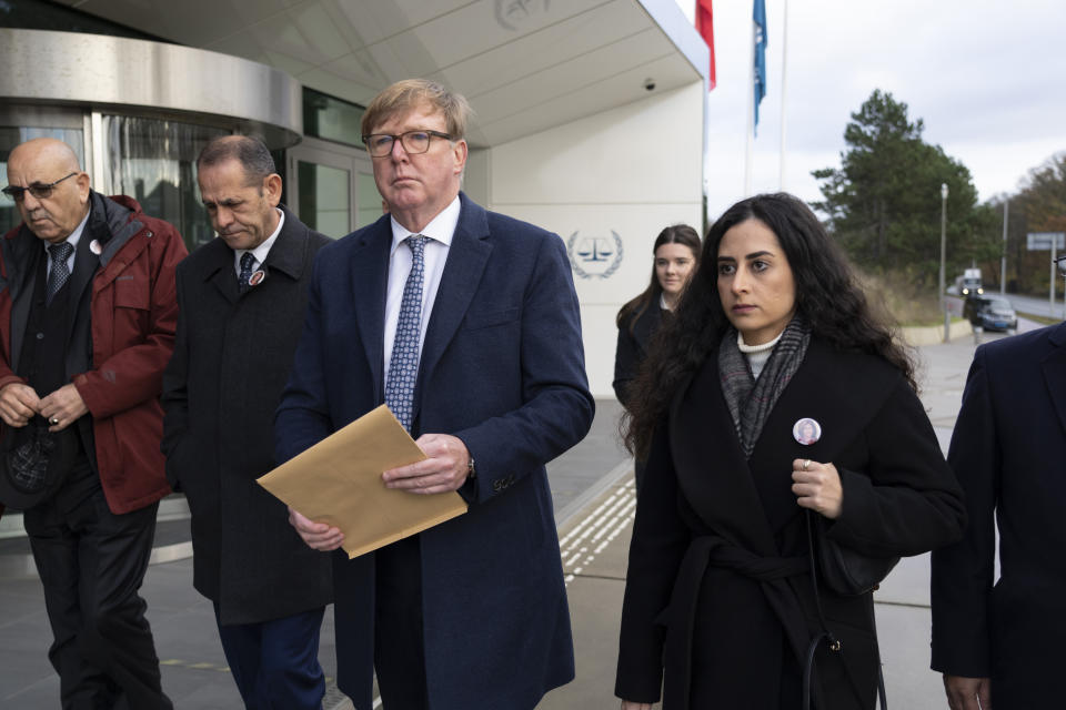 Rodney Dixon, lawyer for Al Jazeera, and Lina Abu Akleh, niece of fatally shot Al Jazeera journalist Shireen Abu Akleh, walk to to the International Criminal Court in The Hague, Netherlands, Tuesday, Dec. 6, 2022, to present a letter requesting a formal investigation into the killing. Palestinian officials, Abu Akleh's family and Al Jazeera accuse Israel of intentionally targeting and killing the 51-year-old journalist, a claim Israel denies. (AP Photo/Peter Dejong)