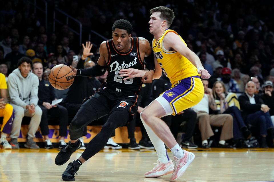 Pistons guard Jaden Ivey, left, drives against Lakers guard Austin Reaves during the first half on Tuesday, Feb. 13, 2024, in Los Angeles.