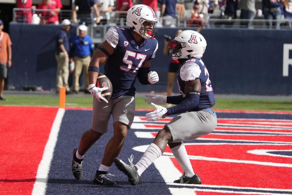 Arizona linebacker Anthony Ward (57) celebrates with running back Nazar Bombata after scoring a touchdown against Utah during the first half of an NCAA college football game, Saturday, Nov. 18, 2023, in Tucson, Ariz. (AP Photo/Rick Scuteri)