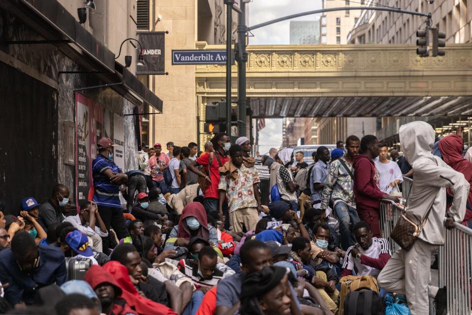 A group of migrant men waits for processing outside the Roosevelt Hotel in midtown Manhattan on Aug. 1. If re-elected, Donald Trump wants to revive his first-term border policies, including banning entry by people from certain Muslim-majority nations and reimposing a COVID-19-era policy of refusing asylum claims -- though this time he would base that refusal on assertions that migrants carry other infectious diseases like tuberculosis.