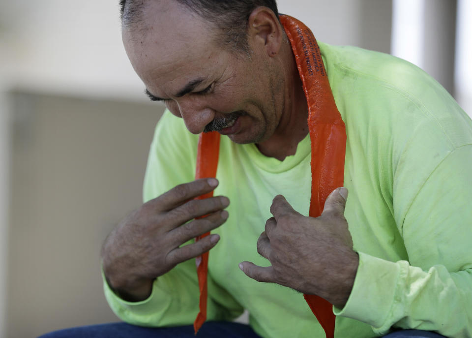 Amado Cobian puts on a wet neck wrap to keep cool during a break from work Tuesday, July 24, 2018, in Las Vegas. The National Weather Service has issued an excessive heat warning for the Las Vegas valley. (AP Photo/John Locher)