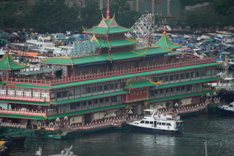 Hong Kong's iconic Jumbo Floating Restaurant is towed away in Hong Kong, Tuesday, June 14, 2022. Hong Kong's iconic restaurant on Tuesday departed the city, after its parent company failed to find a new owner and lacked funds to maintain the establishment amid months of COVID-19 restrictions. (AP Photo/Kin Cheung)