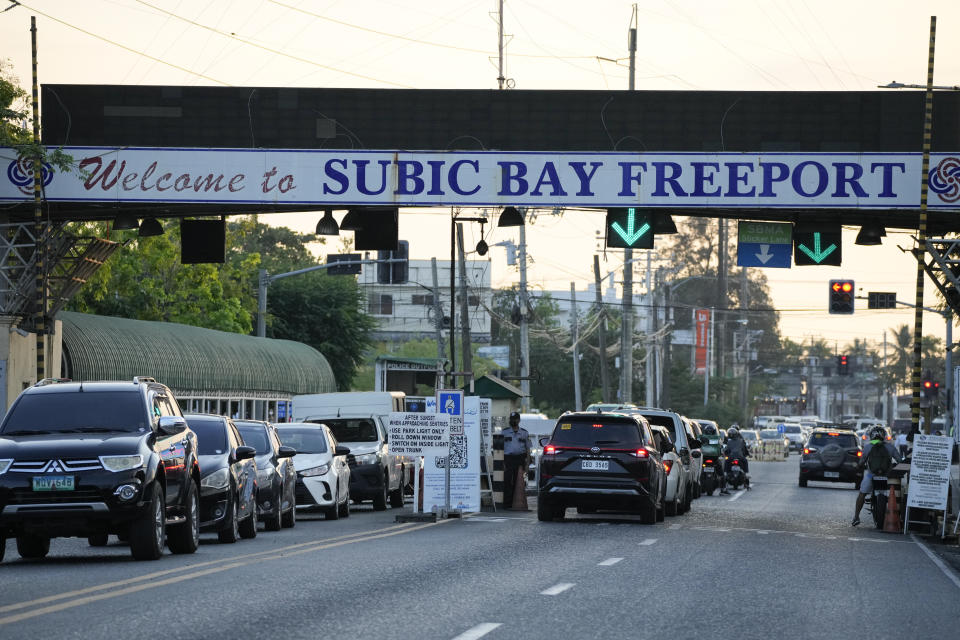 Vehicles pass by one of the gates in what used to be America's largest overseas naval base at the Subic Bay Freeport Zone, Zambales province, northwest of Manila, Philippines on Monday Feb. 6, 2023. The U.S. has been rebuilding its military might in the Philippines after more than 30 years and reinforcing an arc of military alliances in Asia in a starkly different post-Cold War era when the perceived new regional threat is an increasingly belligerent China. (AP Photo/Aaron Favila)