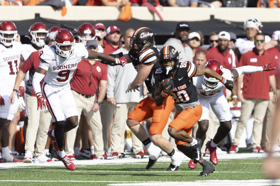 Oklahoma State wide receiver Brennan Presley (80) runs past Oklahoma defensive back Key Lawrence (12) and defensive back Gentry Williams (9) in the first half of an NCAA college football game Saturday, Nov. 4, 2023, in Stillwater, Okla. (AP Photo/Mitch Alcala)