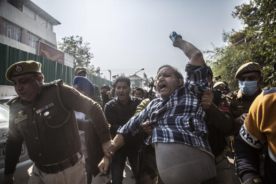 Indian police detain an activist of Peoples Democratic party (PDP) protesting against India's new land laws that allows any Indian citizen to buy land in the disputed region in Srinagar, Indian controlled Kashmir, Thursday, Oct. 29, 2020. Until last year, Indians were not allowed to buy property in the region. But in August 2019, Prime Minister Narendra Modi’s government scrapped the disputed region’s special status, annulled its separate constitution, split the region into two federal territories. (AP Photo/Mukhtar Khan)