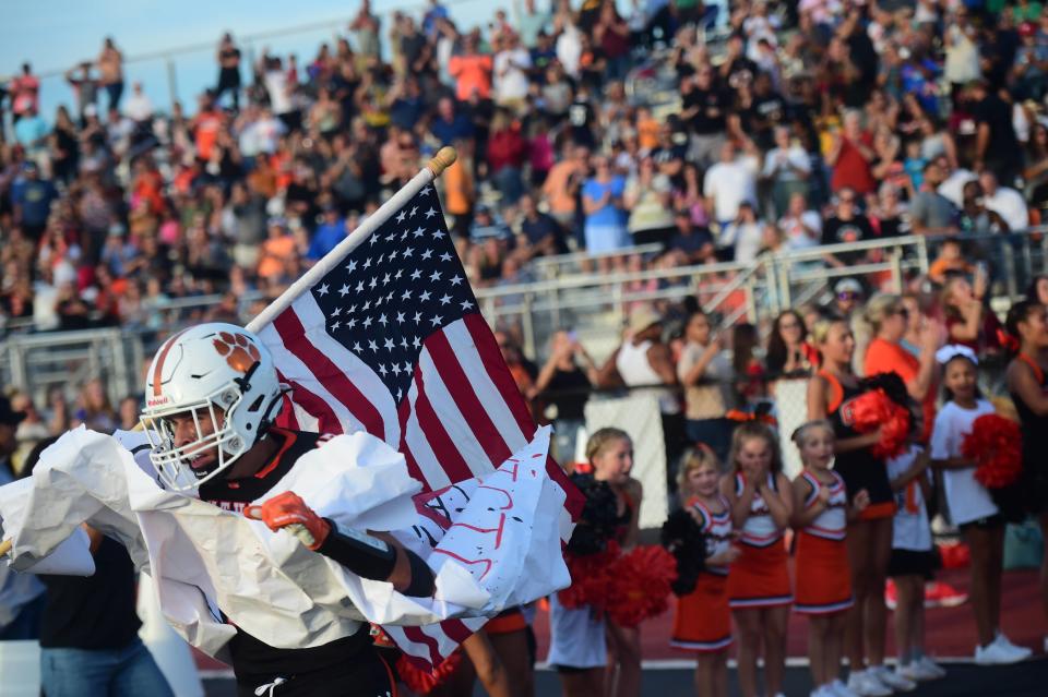 Central York's Joseph Alu carries the American flag as he runs through the banner prior to Friday's football game. Cumberland Valley, beat Central York, 35-33, on the road, Friday, Sept. 2, 2022.
