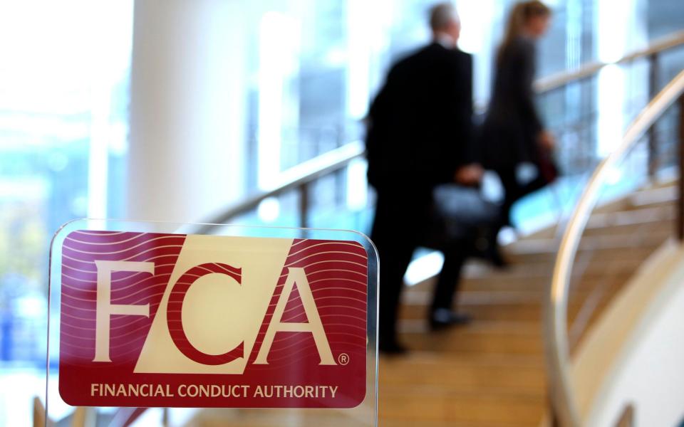 Visitors walk up a staircase as a logo sits on a sign in the reception area of the headquarters of the Financial Conduct Authority (FCA) in the Canary Wharf business district in London - Credit: Chris Ratcliffe/Bloomberg News