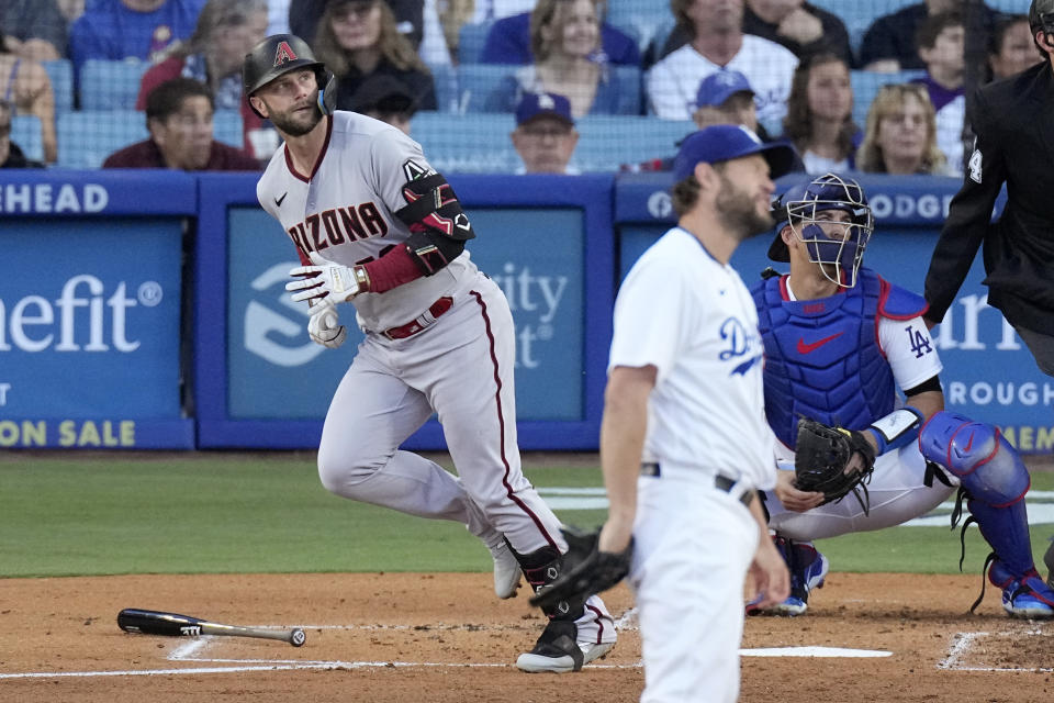 Arizona Diamondbacks' Christian Walker, left, heads to first as he hits a solo home run whileLos Angeles Dodgers starting pitcher Clayton Kershaw, center, reacts and catcher Austin Barnes watches during the second inning of a baseball game Saturday, April 1, 2023, in Los Angeles. (AP Photo/Mark J. Terrill)