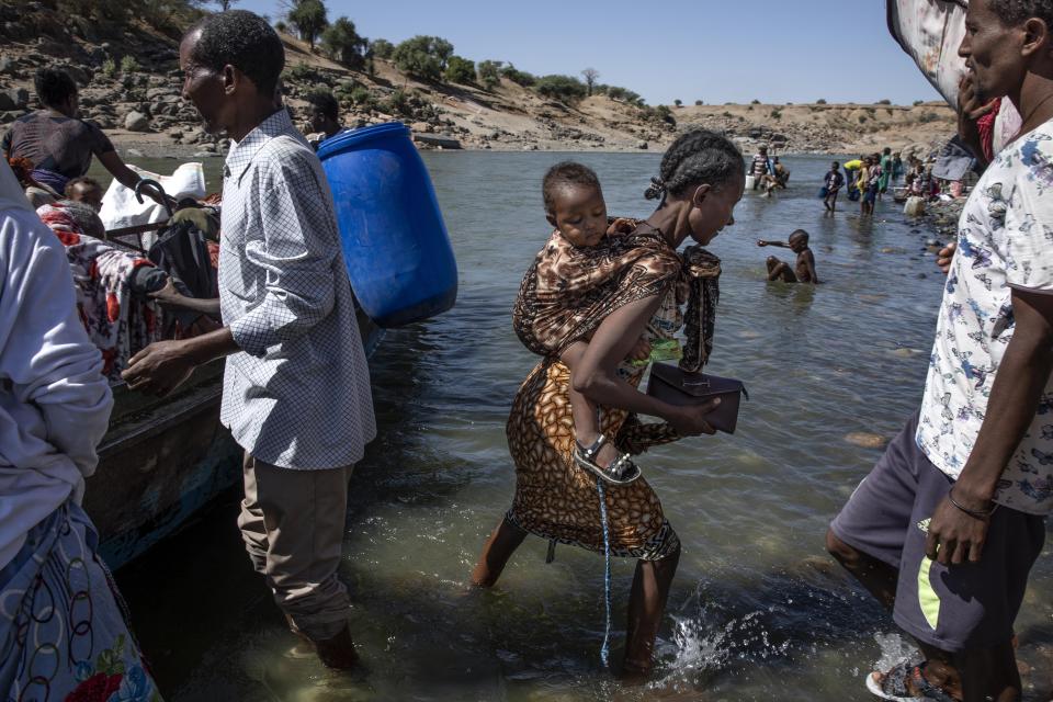 Tigray refugees who fled the conflict in the Ethiopia's Tigray arrive on the banks of the Tekeze River on the Sudan-Ethiopia border, in Hamdayet, eastern Sudan, Tuesday, Dec. 1, 2020. (AP Photo/Nariman El-Mofty)