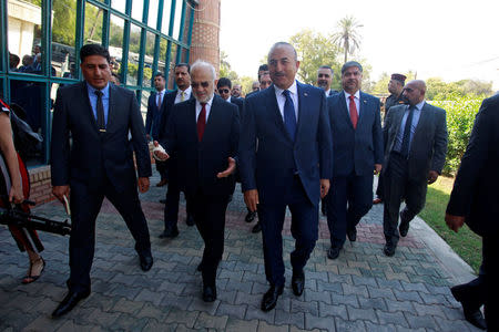 Turkish foreign minister Mevlut Cavusoglu walks with Iraqi Foreign Minister Ibrahim al-Jaafari in Baghdad, Iraq August 23, 2017. REUTERS/Khalid al Mousily