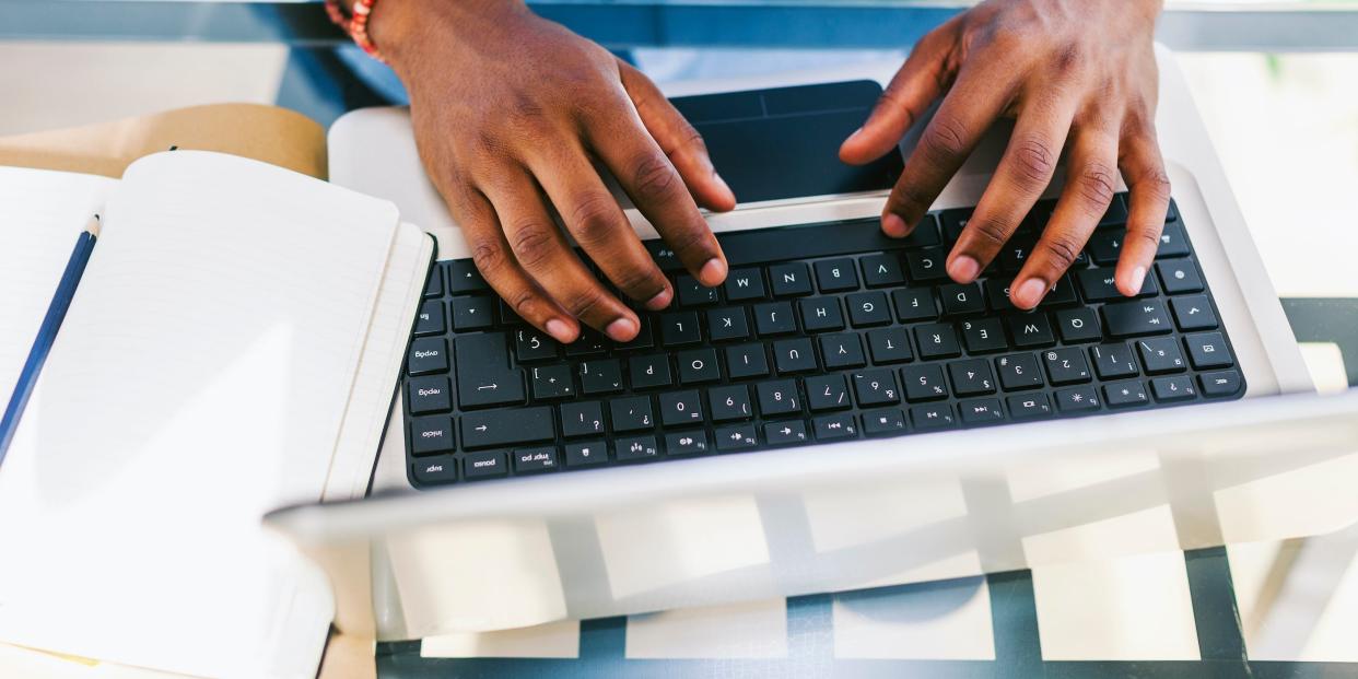 man using keyboard on laptop computer