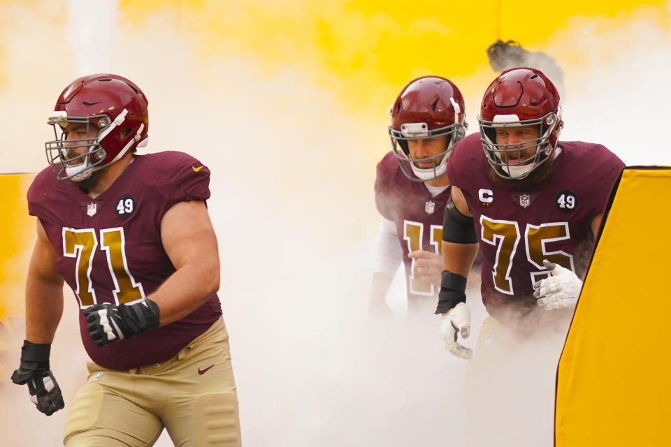 Members of the Washington Football Team taking the field, from l-r., offensive guard Wes Schweitzer (71), quarterback Alex Smith (11) and offensive guard Brandon Scherff (75) before the start of the first half of an NFL football game, Sunday, Nov. 22, 2020, in Landover. (AP Photo/Andrew Harnik)