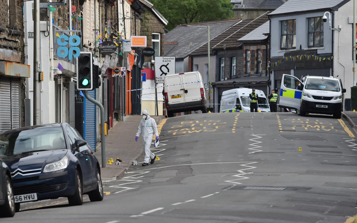 Forensic officers at the scene of a reported stabbing in the village of Pen Y Graig in South Wales.