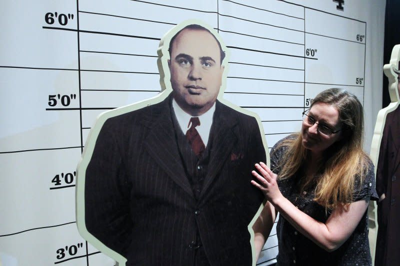 Amanda Bailey with the Missouri History Museum adjusts a cutout figure of Al Capone as final preperations are made for the exhibit American Spirits: The Rise and Fall of Prohibition in St. Louis on April 22, 2014. On October 17, 1931, Capone is convicted of income tax evasion. It took jurors four days to decide whether the mobster had cheated the Internal Revenue Service out of $215,000. File Photo by Bill Greenblatt/UPI