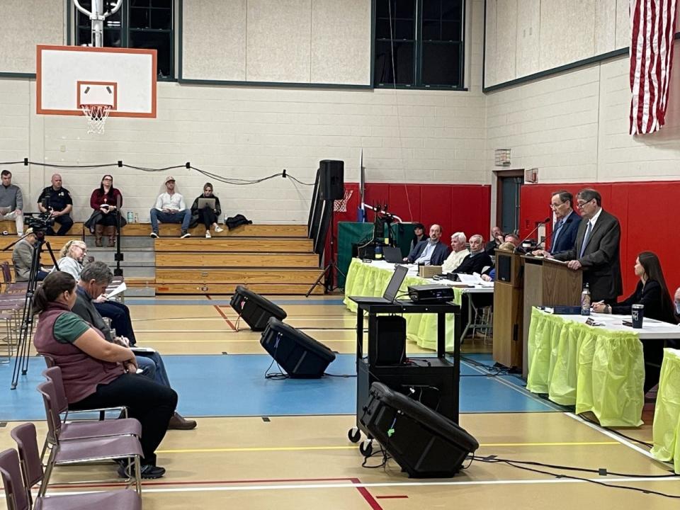 Harwich Finance Committee Chair Peter Hughes, left (at podium), and Town Moderator Michael Ford answer voter questions about an article related to the West Harwich First Baptist Church at the special town meeting on Tuesday.