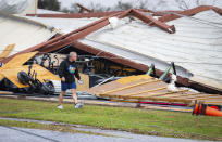 A man walks by a former CrossFit gym that collapsed where a tornado was reported to pass along Mickey Gilley Boulevard near Fairmont Parkway, Tuesday, Jan. 24, 2023, in Pasadena, Texas. (Mark Mulligan/Houston Chronicle via AP)