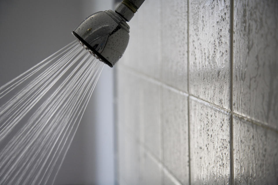 A shower head turned on, spraying water