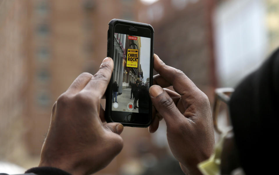 A person records video of the marquee advertising Chris Rock outside the Wilbur Theatre, Wednesday, March 30, 2022, in Boston. (AP Photo/Mary Schwalm)