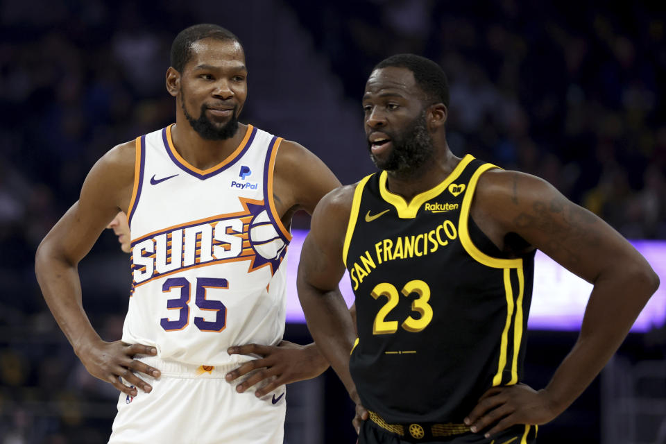 Phoenix Suns forward Kevin Durant (35) speaks with Golden State Warriors forward Draymond Green (23) during the first half of an NBA basketball game in San Francisco, Saturday, Feb. 10, 2024. (AP Photo/Jed Jacobsohn)