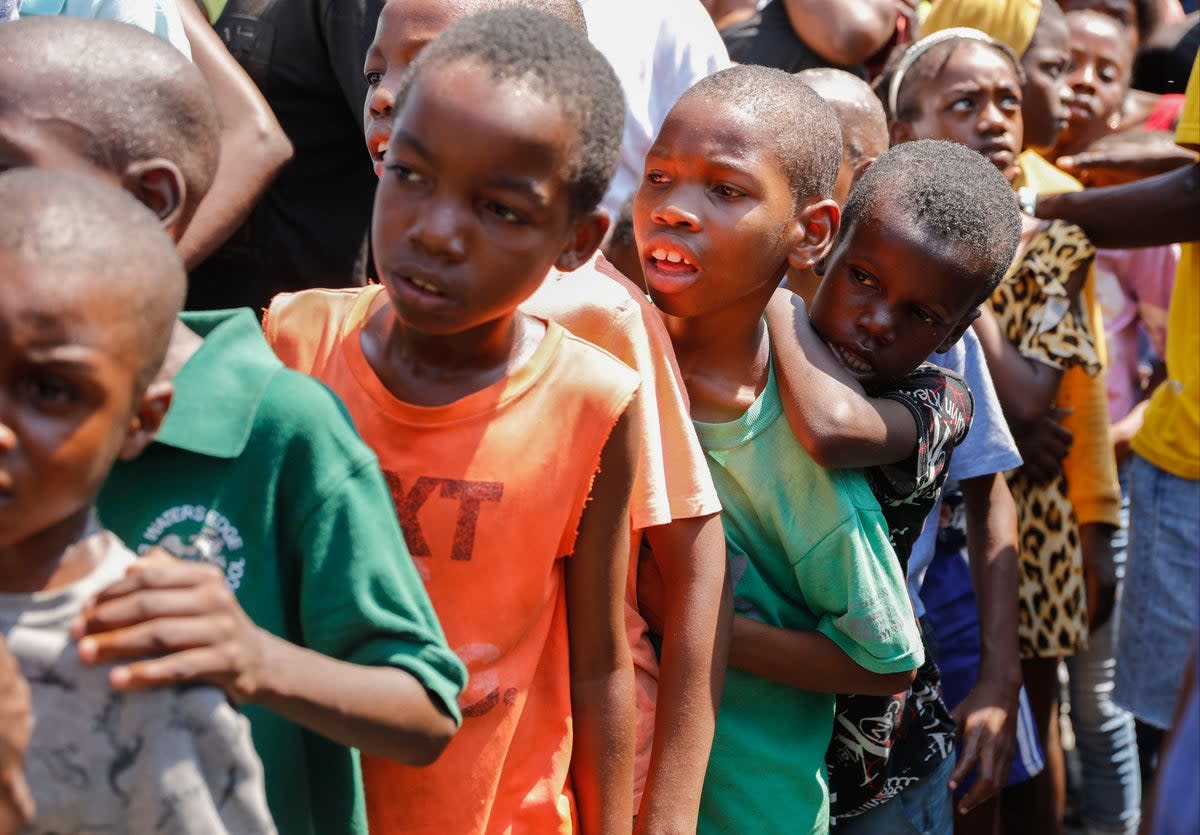 Children line up to receive a plate of food at a shelter for families displaced by gang violence, in Port-au-Prince, on March 14 (AP)