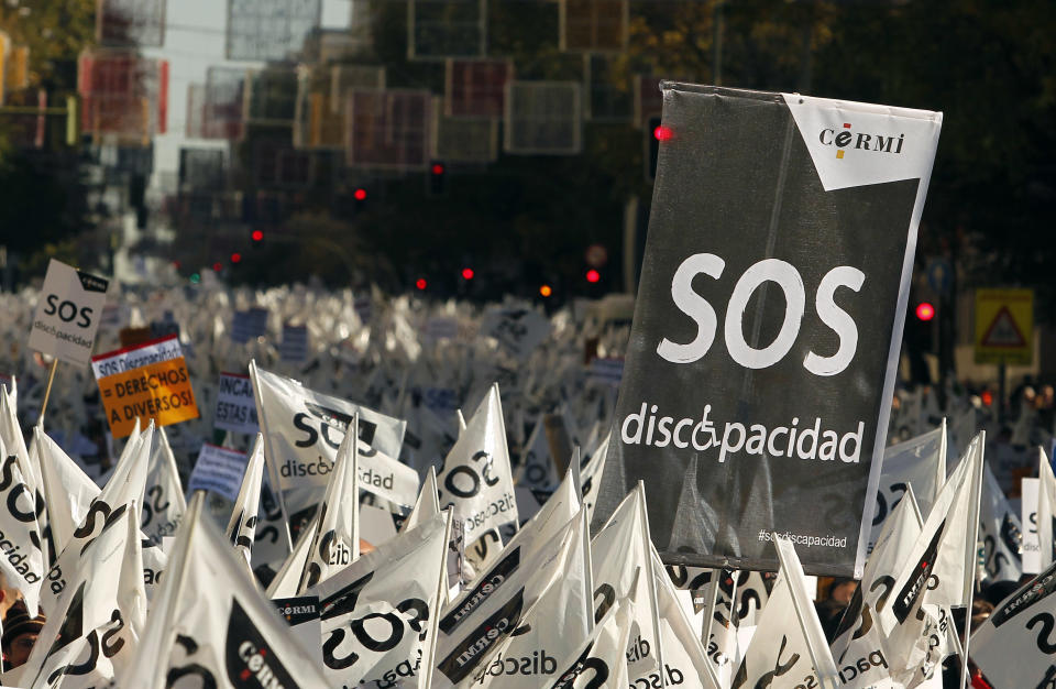 People march as they carry banners reading, "SOS, disability" during a protest against government austerity measures affecting disabled people by reducing services, closing disability centers and forcing care workers from their jobs in Madrid, Spain, Sunday, Dec. 2, 2012. More than 10,000 people, many in wheelchairs or being led by guide dogs, marched in a demonstration with the slogan "SOS Disability: Save our Rights, Inclusion and Welfare." Health care spending falls under the responsibility of regional governments, many of which are indebted. Some local administrations have failed to pay medical centers, forcing cuts in services and a slow-down in the distribution of medicine. (AP Photo/Andres Kudacki)