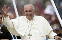 Pope Francis waves as he travels on the Popemobile along the streets of Quito on July 5, 2015